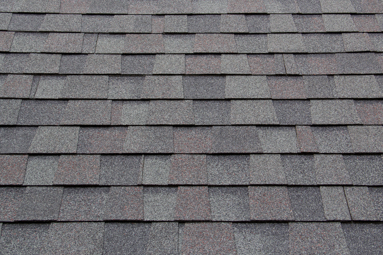 dark new roof shingle background and texture. asphalt tiles of house roof.