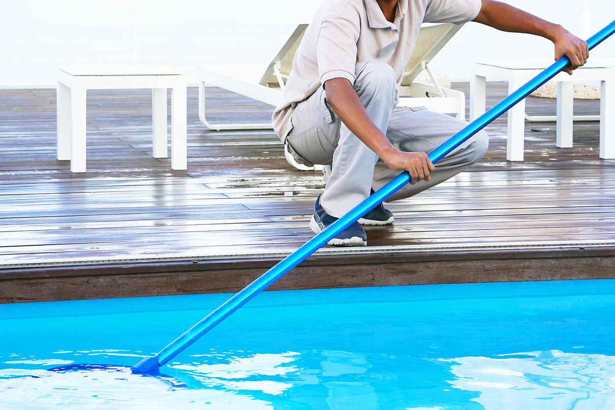 Hotel staff worker cleaning the pool