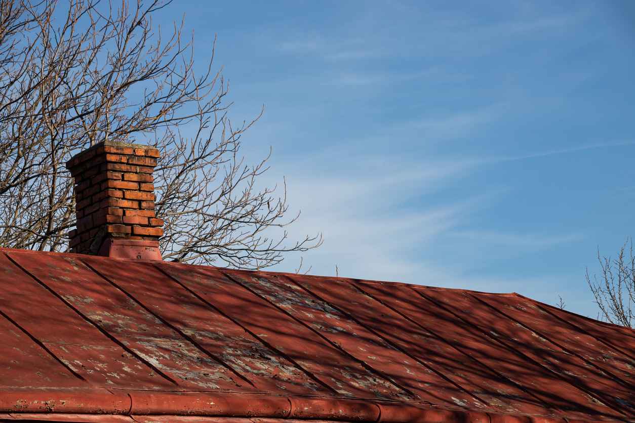 Roof and chimney from an old house - brick and metallic texture; Signs Your Roof Needs Repair